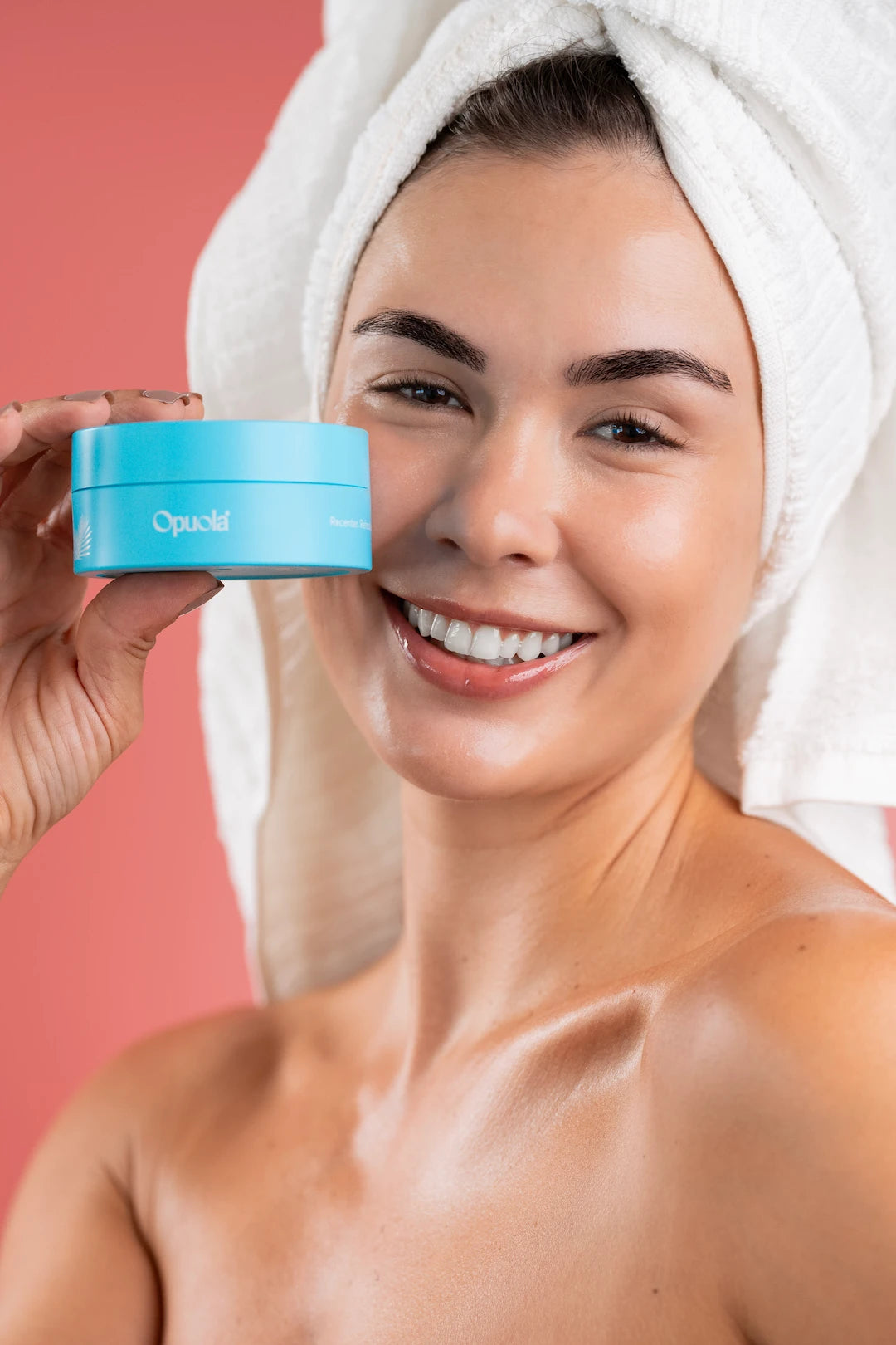 Woman with towel holding Opuola Aloha Blue hydrating under-eye patches designed to reduce puffiness and dark circles in 15 minutes
